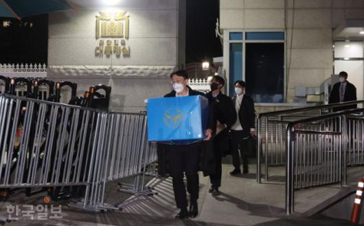 지난해 12월 11일 경찰청 국가수사본부 비상계엄 특별수사단 수사관들이 용산 대통령실에서 압수물 박스와 포렌식 장비 등을 챙겨 청사를 나서고 있다. 왕태석 선임기자