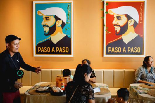 이달 1일 엘살바도르 산살바도르의 한 카페에 나이브 부켈레 대통령의 얼굴과 '한 걸음 한 걸음'이라는 문구가 그려진 포스터가 걸려 있다. 산살바도르=로이터 연합뉴스