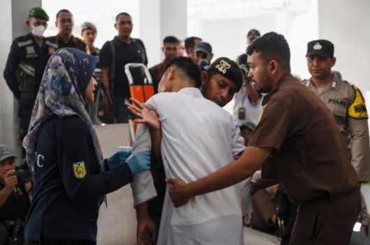 지난 2월 인도네시아 아체특별자치주 반다아체에서 샤리아법 집행관들이 태형을 당한 뒤 쓰러진 남성을 붙잡고 있다. 반다아체=AP 연합뉴스 자료사진