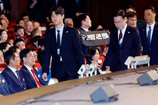 이재명(맨 앞줄 오른쪽) 대통령이 15일 서울 종로구 세종문화회관에서 열린 80주년 광복절 경축식에서 축사를 마친 뒤 1인 시위 중인 안철수(셋째 줄 가운데) 국민의힘 의원을 지나쳐 이동하고 있다. 연합뉴스