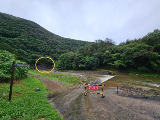 지난 12일 울산 울주군 천전리 명문과 암각화(동그라미 친 부분)로 향하는 교량이 물에 잠겨 출입이 통제되고 있다. 울산= 박은경 기자