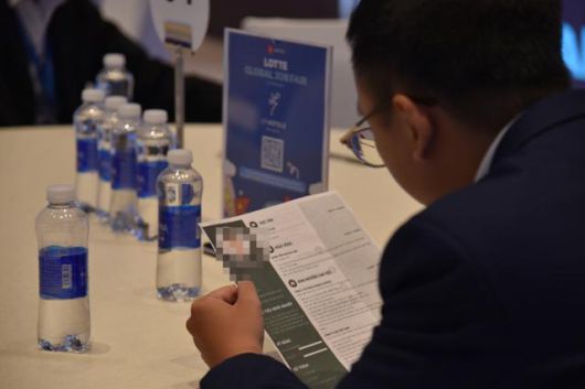 22일 베트남 하노이 L7 웨스트레이크에서 열린 ‘2025 롯데 글로벌 잡페어’에서 한 실무자가 상담 신청자의 이력서를 살피고 있다. 하노이=허경주 특파원