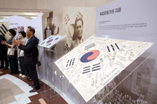 전시회 참석자들이 18일 국회 도서관 로비에서 열린 '광복80주년 국회 특별전 오늘 다시 보았네, 우리 태극기 전시회'에서 박수를 치고 있다. 뉴시스