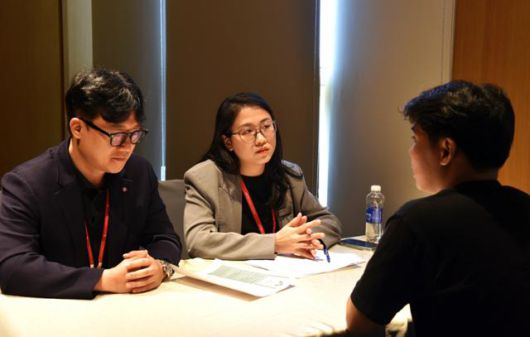 22일 베트남 하노이 L7 웨스트레이크에서 열린 ‘2025 롯데 글로벌 잡페어’에서 롯데그룹 관계자들이 베트남 현지인 취업 희망자와 모의 면접을 진행하고 있다. 하노이=허경주 특파원