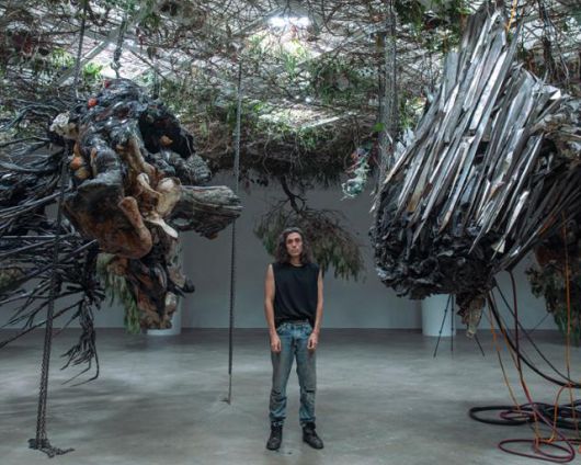 작가 아드리안 비야르 로하스가 '적군의 언어' 전시장에 설치된 '상상의 종말' 연작 사이에 서 있다. 그의 조각들은 수만 년 뒤 미래에 존재할 수 있는 변형된 조각의 모습이다. 아트선재센터 제공