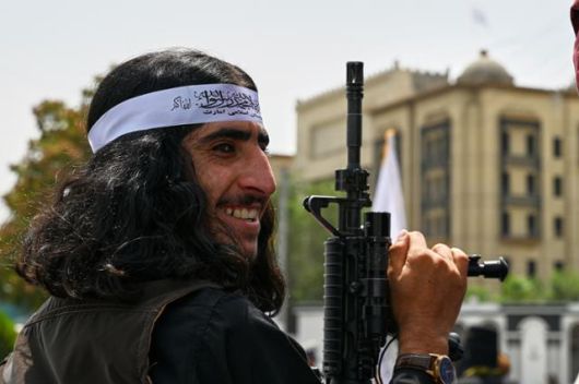 한 이슬람 무장단체 탈레반 조직원이 8월 15일 아프가니스탄 카불에서 미국 철수 4주년을 기념하는 행사에 참석해 미소 짓고 있다. 카불=AP 연합뉴스