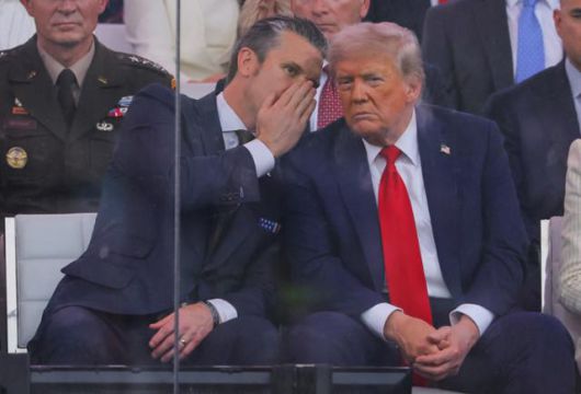 피트 헤그세스(왼쪽) 미국 국방장관이 6월 워싱턴에서 열린 미 육군 창설 250주년 기념 열병식에 참여해 도널드 트럼프 대통령에게 귓속말을 하고 있다. 워싱턴=로이터 연합뉴스