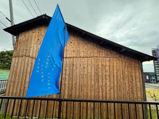 '우리는 우토로에서 살아왔고 우토로에서 죽으리라'고 적힌 깃발이 12일 일본 교토부 우지시 우토로평화기념관에 설치된 함바 앞에 흔들리고 있다. 당시 비행장 건설에 강제 동원된 재일 조선인들은 우토로 내 지어진 가설 숙소인 함바에 모여 살았다. 우지=류호 특파원