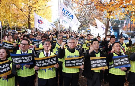 김택우 대한의사협회 회장을 비롯한 참석자들이 16일 서울 여의도 국회 앞에서 열린 국민건강수호 및 의료악법저지를 위한 전국의사 대표자 궐기대회에서 손피켓을 들고 구호를 외치고 있다. 뉴스1