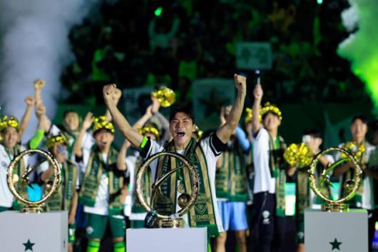 K리그1 전북 현대의 주장 박진섭(맨 앞)이 8일 전북 전주월드컵경기장에서 열린 우승 시상식에서 올 시즌 우승트로피를 역대 우승트로피 사이에 놓은 후 두 팔을 번쩍 들어 올리며 환호하고 있다. 전주=뉴스1