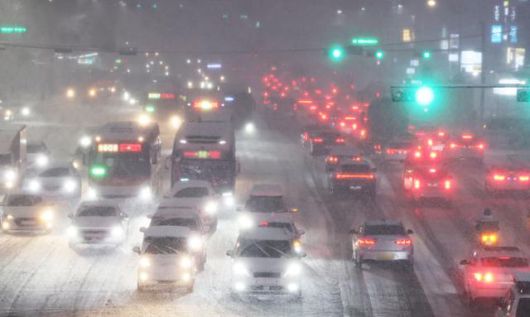 4일 경기 수원시 수원역 앞 덕영대로에서 쏟아진 폭설에 차량이 서행하고 있다. 연합뉴스