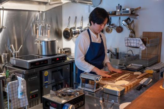 신정원 셰프가 주방에서 우동 면처럼 굵은 피치 파스타를 만들고 있다.