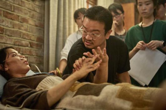 연상호 감독이 넷플릭스 드라마 '지옥' 촬영장에서 배우 김신록에게 연기에 대해 이야기하고 있다. 넷플릭스 제공