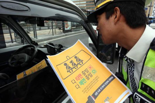 개정된 도로교통법이 시행되며 전 좌석 안전띠 착용이 의무화된 2018년 10월 서울 세종로사거리에서 교통경찰이 홍보전단을 배포하고 있다. 류효진 기자