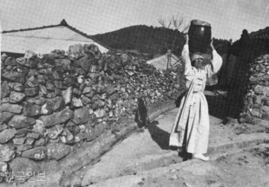 전남 신안군 안좌면에서 한복 차림의 여성이 항아리를 머리에 이고 담벼락을 지나고 있다. 한국일보 자료사진