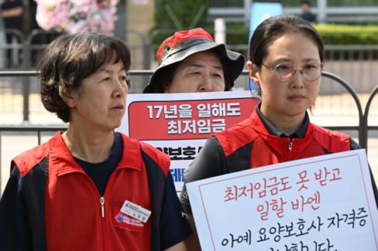 돌봄노동 종사자들이 지난해 6월 27일 서울 용산구 대통령실 앞에서 최저임금 업종별 차별 적용 반대 및 대폭 인상 촉구 기자회견을 진행하고 있다. 박시몬 기자