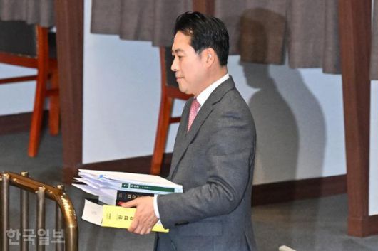 장동혁 국민의힘 대표가 22일 국회에서 열린 본회의에서 내란전담재판부 설치 특별법 등에 대한 필리버스터(무제한 토론)을 하기 위해 헌법학 책을 비롯한 자료를 들고 발언대로 향하고 있다. 민경석 기자