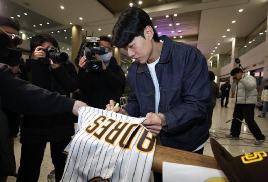미국프로야구 메이저리그(MLB) 샌디에이고 파드리스와 4년 계약을 맺은 ○○○이 23일 인천국제공항에 입국한 뒤 유니폼에 사인을 해주고 있다. 연합뉴스