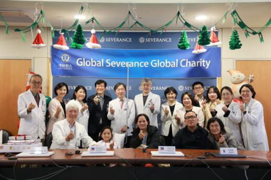 23일 서울 서대문구 세브란스병원에서 조안나(앞줄 왼쪽 두 번째)와 조안나의 어머니(세 번째), 집도의 김동석(첫 번째) 소아신경외과 교수, 이정현 선교사(네 번째)와 세브란스 임직원들이 기념사진을 찍고 있다. 세브란스병원 제공