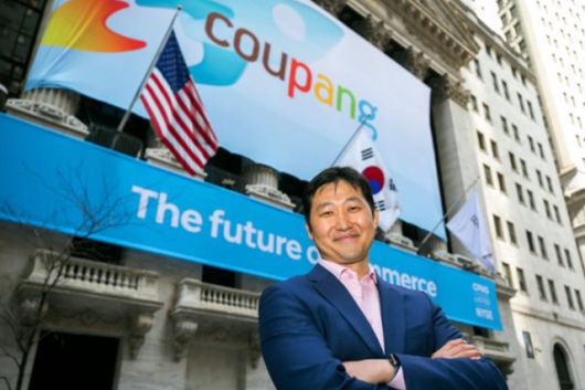 김범석 쿠팡 Inc 이사회 의장이 미국 뉴욕증권거래소(NYSE) 상장 첫날인 2021년 3월 11일 쿠팡 배너가 정면을 장식한 NYSE 앞에서 웃으며 포즈를 취하고 있다. 뉴욕=AP 연합뉴스