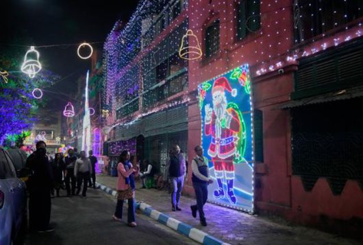 23일 인도 콜카타의 보우 배럭 주택가에서 시민과 관광객들이 크리스마스 장식이 된 거리를 거닐고 있다. 콜카타=AP/뉴시스