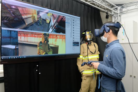 HMD 착용자를 가상 화재현장에서 소방관으로 구현해주는 기술 시연 모습.[ETRI 제공]