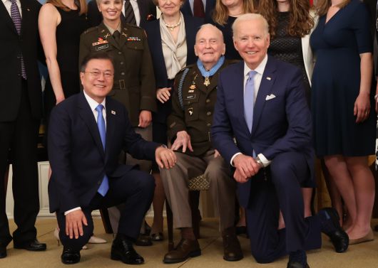 마스크를 벗고 기념촬영하고 있는 문재인(왼쪽) 대통령과 조 바이든(오른쪽) 미국 대통령, 랠프 퍼켓 주니어(가운데) 예비역 대령. 문재인 대통령은 21일 오후(현지시간) 백악관 이스트룸에서 열린 한국전쟁 명예 훈장 수여식에 참석해 혈맹행보를 이어갔다. [연합]