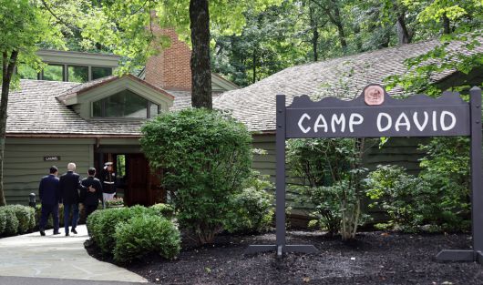 윤석열 대통령과 조 바이든 미국 대통령, 기시다 후미오 일본 총리가 18일(현지시간) 워싱턴DC 인근 미국 대통령 별장인 캠프 데이비드에서 기념 촬영을 마치고 한미일 정상회의를 위해 로렐 로지로 들어가고 있다. [연합]