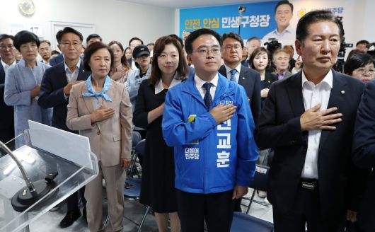 23일 더불어민주당 강서구청장 보궐선거 진교훈 후보 선거사무소 개소식에서 진 후보와 정청래 의원 등이 국민의례를 하고 있다.[연합]