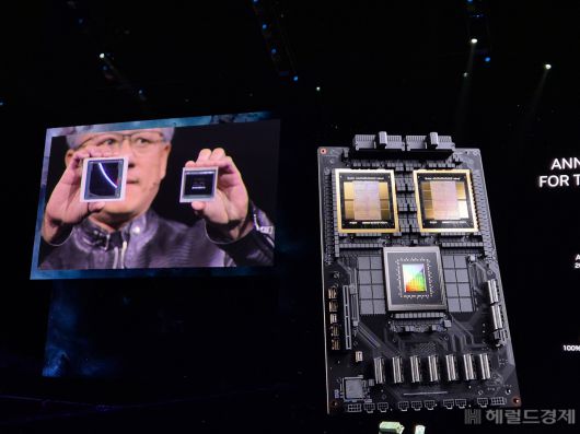 젠슨 황 엔비디아 최고경영자(CEO)가 18일(현지시간) 오후 미국 캘리포니아주 새네제이 SAP센터에서 열린 ‘엔비디아 GPU 테크놀로지 콘퍼런스 2024(이하 GTC 2024)’ 기조연설에서 차세대 AI 반도체 ‘블랙웰’(Blackwell)을 소개하고 있다. 왼손에 들고 있는 것은 기존 제품인 ‘H100’, 오른손에 있는 것이 이번에 공개한 블랙웰 GPU ‘B100’이다. 크기 차이가 확연하다. 사진=김현일 기자(새너제이)