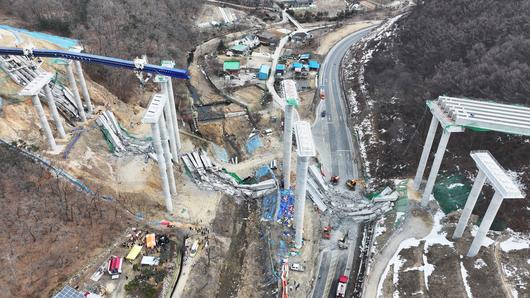 25일 경기도 안성시 서운면 산평리 소재 서울세종고속도로 천안~안성구간 9공구 천용천교 건설 현장에서 교량 연결작업 중 교각에 올려놓았던 상판이 무너지는 사고가 발생했다.  사진은 사고 현장 모습. [연합]