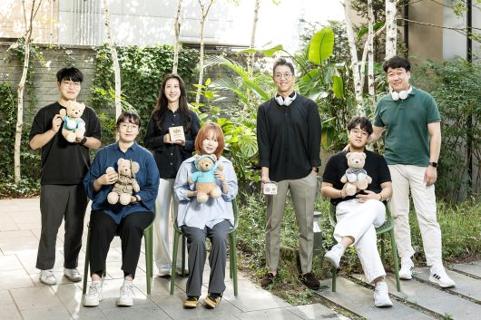 배익렬 스트레스솔루션 대표와 임직원이 전시에서 선보일 예정인 테디베어 수면 인형을 들고 포즈를 취하는 모습. [SK텔레콤 제공]