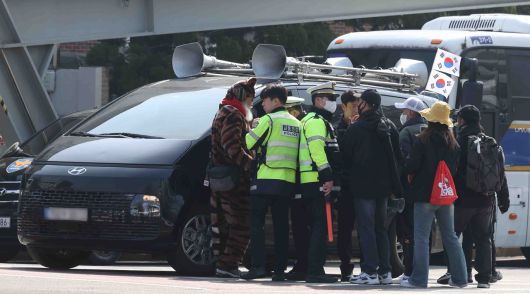 21일 오전 서울 종로구 헌법재판소 인근에서 경찰이 차량 확성기 시위를 하는 윤 대통령 지지자를 막고 있다.[뉴시스]