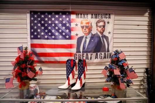 도널드 트럼프 미국 대통령과 JD 밴스 부통령의 모습이 그려진 성조기가 2025년 플로리다 제6선거구 특별선거 공화당 후보 랜디 파인의 시계 파티 장소에 놓여 있다. [로이터]