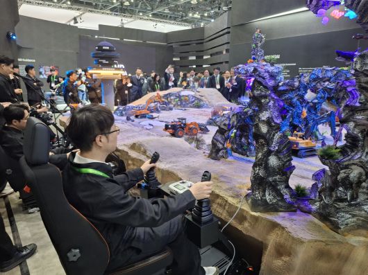 HD현대 부스내 직원들이 기계장비 모형을 조작하고 있다. [고양=김성우 기자]