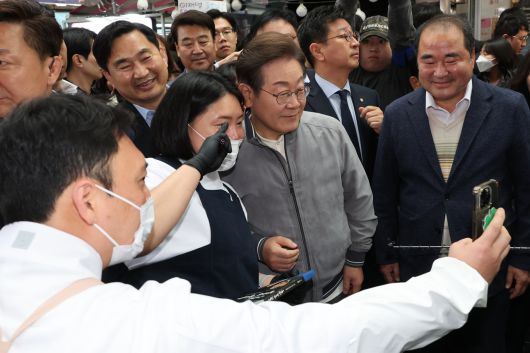 더불어민주당 이재명 대선 후보가 ‘골목골목 경청투어’ 사흘째인 3일 ‘동해안벨트’ 첫 방문지인 강원도 속초시 중앙재래시장에서 ‘성게 초콜릿’을 만든 청년 상인들과 사진을 찍고 있다. [연합]