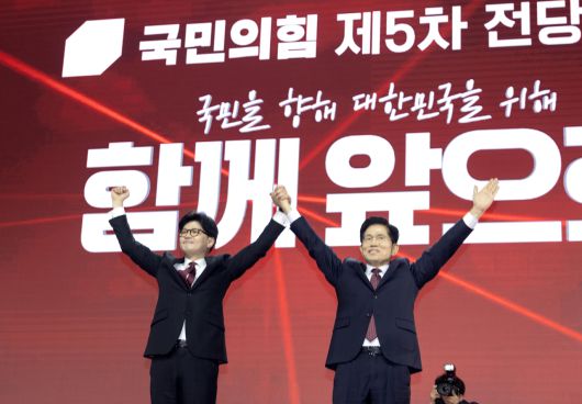 국민의힘 한동훈 대선 경선 후보와 김문수 후보가 3일 경기 고양시 킨텍스에서 열린 국민의힘 최종 대선 후보 선출을 위한 전당대회에서 손을 들어올리고 있다. [연합]