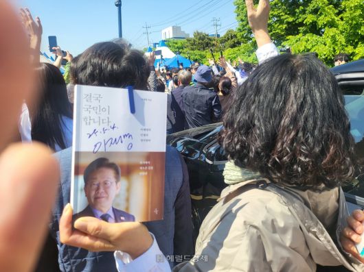 이후보의 자서전을 든 일부 지지자가 현장에서 사인을받아 들어보이고 있다.[사진=김성권 기자]