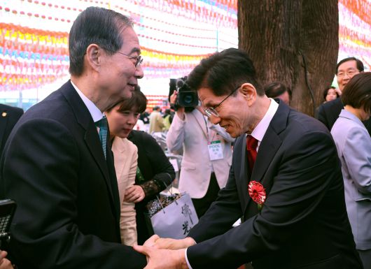 김문수(오른쪽) 국민의힘 대선 후보와 무소속 한덕수 대선 예비후보가 5일 서울 종로구 조계사에서 열린 불기 2569년 부처님오신날 봉축법요식을 마친 뒤 악수하고 있다. [연합]