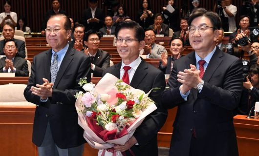김문수(가운데) 국민의힘 대선 후보가 9일 오전 서울 여의도 국회에서 열린 의원총회에서 꽃다발을 받은 뒤 기념촬영 하고 있다. 왼쪽부터 권영세 비대위원장 김 후보, 권성동 원내대표. 임세준 기자