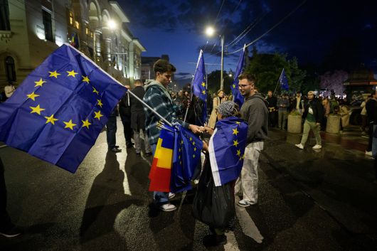 18일(현지시간) 루마니아 부쿠레슈티에서 유럽연합(EU)과 루마니아 국기가 흔들리고 있다. [AP]