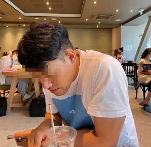 카페에서 휴대폰을 보고 있는 남자. [독자 제공]