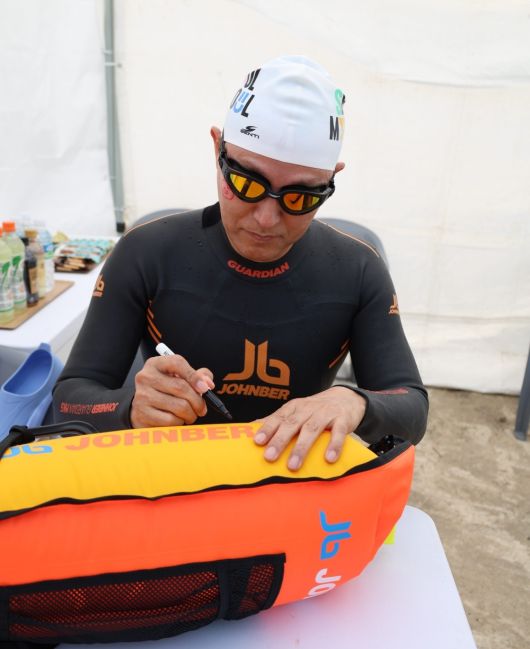 쉬엄쉬엄 한강 3종 축제’ 1일차 수영종목 출발에 앞서 안전부이에 ‘수영하기 너무 좋은 한강으로 오세요, 수질 환상적!’ 문구를 쓰고 있다. [서울시 제공]