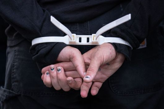 10일(현지시간) 미 뉴욕에서 트럼프 대통령의 불법 이민 단속에 반발하는 시위대 일부가 경찰에 검거돼 케이블 타이로 만든 수갑에 연행되고 있다. [AFP]