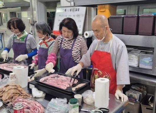 문빈정사 주지 법공스님이 12일 광주 남구 성요셉사랑의식당에서 저소득층을 위한 삼겹살 후원 행사로 삼겹살을 굽고 나르고 있다.(오영순 광주 남구의원 SNS.