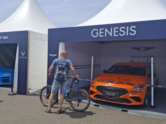 팬존에 마련된 제네시스 GV60 마그마 전시차량 앞에서 자전거를 끌고온 현지 팬이 차량을 살피고 있다. [김성우 기자]