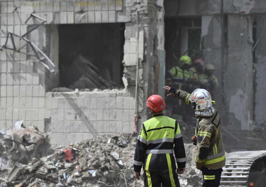 우크라이나 구조대가 18일(현지시간) 수도 키이우에서 드론과 미사일 공습을 받은 건물 폐허를 수색하고 있다. [AFP]