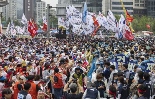 21일 서울 종로구 광화문에서 한국노총과 민주노총 소속 공공기관 노조가 공동 참가한 총력 투쟁 결의대회에 집회 참석 노조의 깃발들이 입장하고 있다. [연합]