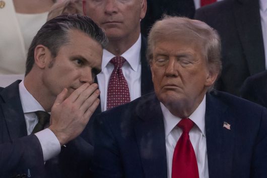 헤그세스 국방장관이 14일(현지시간) 행사 중 트럼프 대통령에게 귓속말을 하고 있다. [로이터]