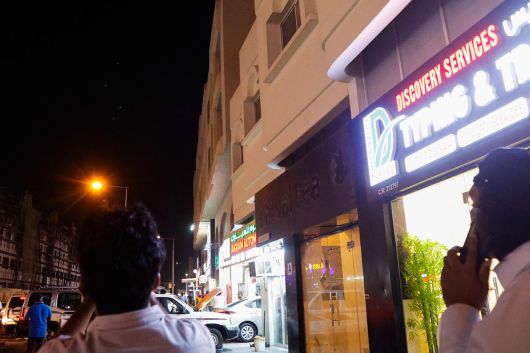 카타르 수도 도하에서 사람들이 23일(현지시간) 밤 팽팽한 긴장감 속에서 이란이 발사한 미사일을 바라보고 있다. [AFP]